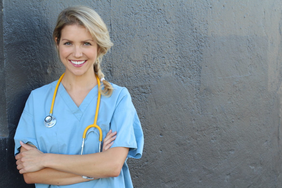 Young beautiful successful female doctor with stethoscope – portrait with copy space